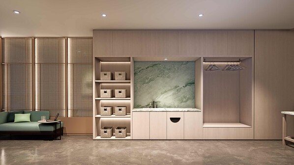 A modern interior with a sofa, storage units, and a wall-mounted mirror. - Holiday Inn Wuhu Jiangbei New Area By Ihg (Wuhu)