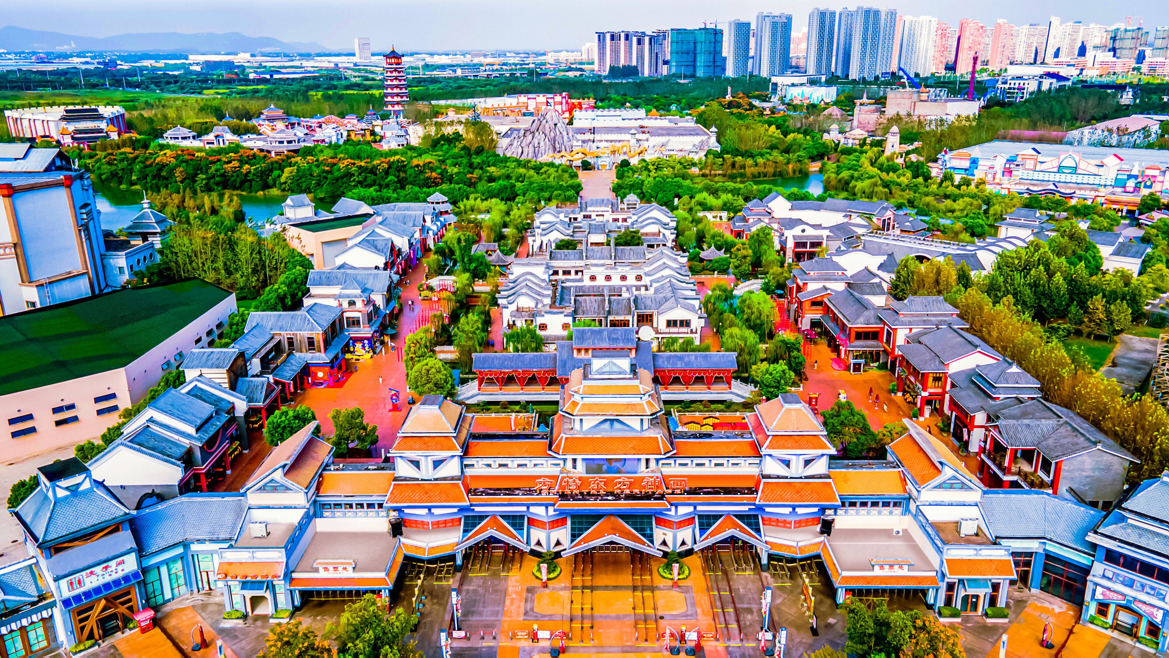 Un ensemble architectural chinois traditionnel comprenant plusieurs bâtiments, une cour centrale et une végétation luxuriante tout autour.