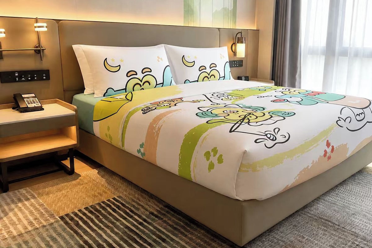 A hotel room with a bed, bedside tables, a phone, and a window with curtains.