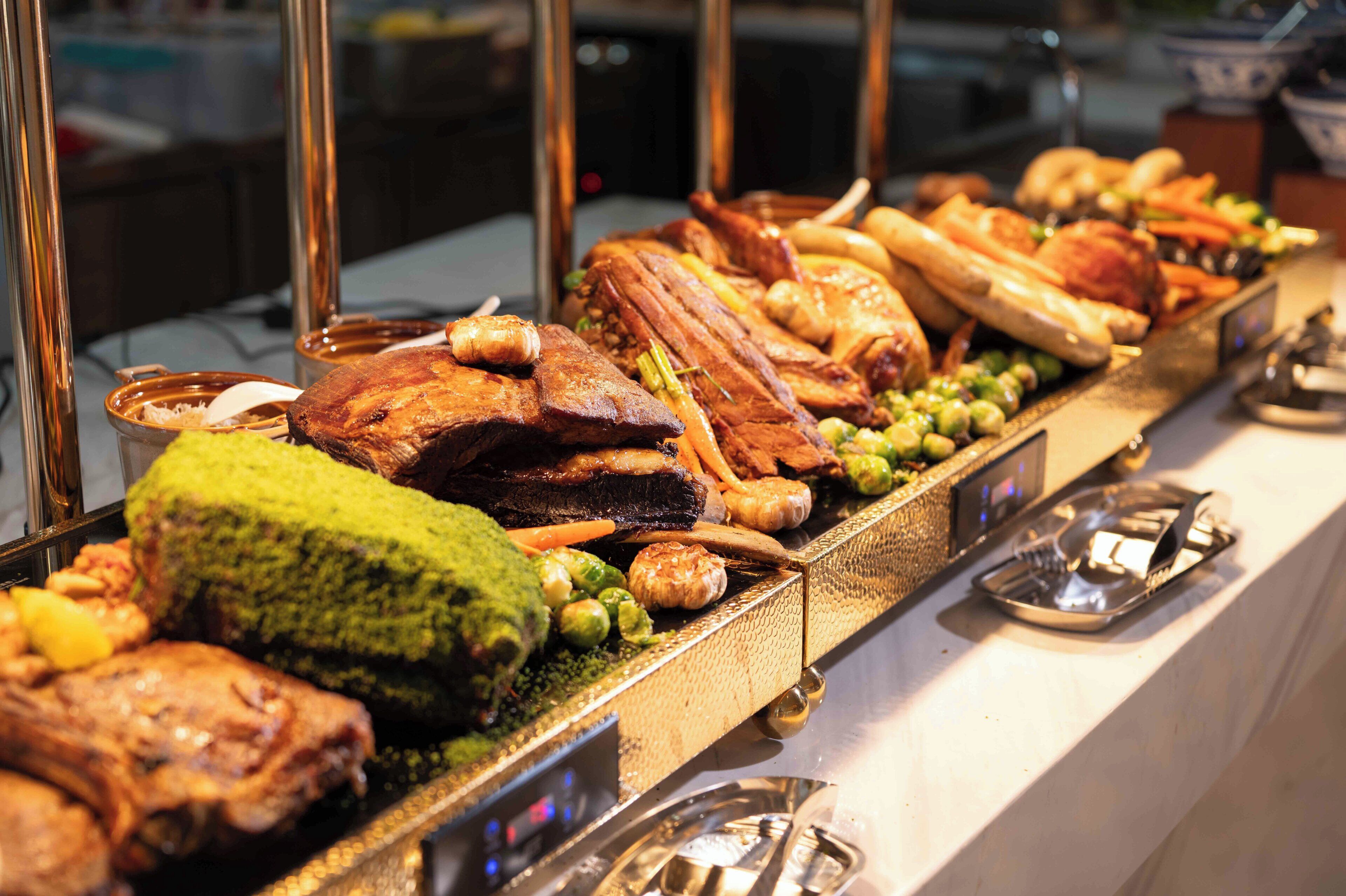 A buffet with various meats and vegetables.