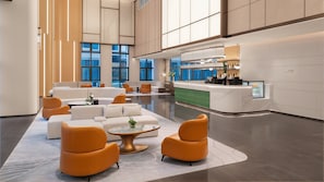 A spacious lobby with seating areas, a reception desk, and a bar. - Holiday Inn Wuhu Jiangbei New Area By Ihg (Wuhu)