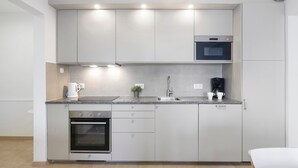 A modern kitchen with built-in appliances, a sink, and a countertop. - Apartment 'Fantástico T2 Albufeira Centro' with Sea View, Wi-Fi and Air Conditioning (Albufeira)