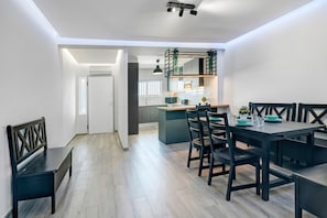 Eine moderne Küche mit Essbereich, Holzboden und einer Bank.