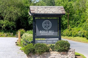 Placa indicando Bickley Mill, uma pousada campestre e local para casamentos, com oferta de almoço de domingo tradicional.