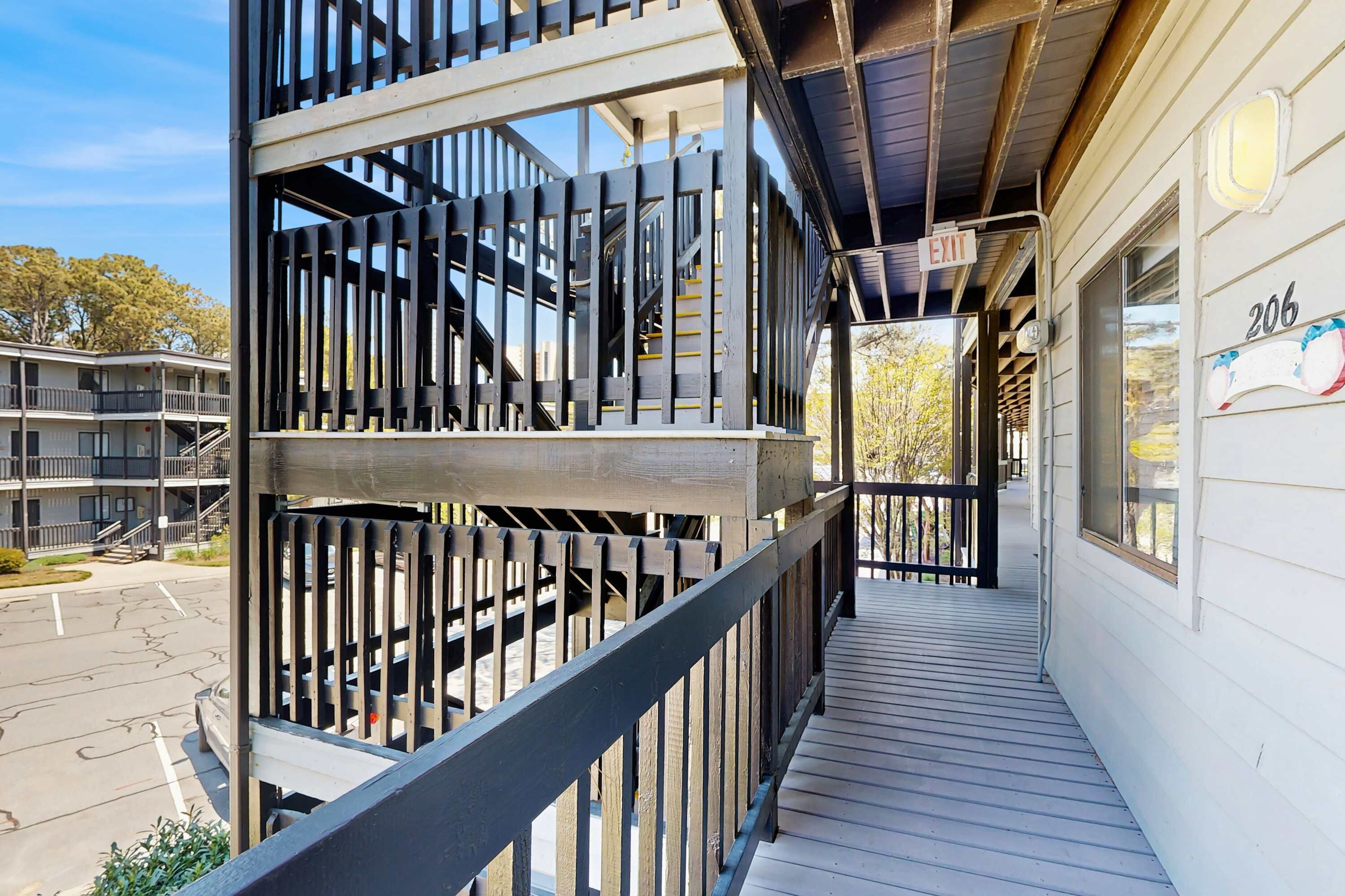 Ein mehrgeschossiges Gebäude mit Balkon, Treppe und einem Hinweisschild für den Ausgang.