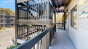 A multi-story building with a balcony, a staircase, and an exit sign. - Our Place At The Beach 206G (Ocean City)
