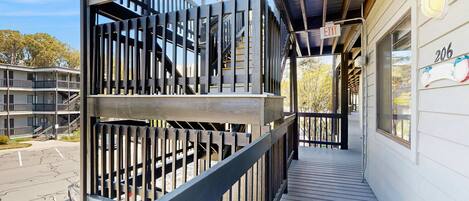 Ein mehrgeschossiges Gebäude mit Balkon, Treppe und einem Hinweisschild für den Ausgang.