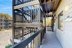 Ein mehrgeschossiges Gebäude mit Balkon, Treppe und einem Hinweisschild für den Ausgang.