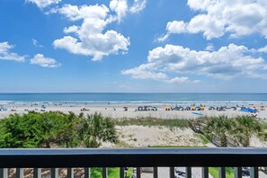 A beach view with palm trees, a wooden walkway, and beach umbrellas. - The Coastal Crab Beachfront Retreat (Surfside Beach)