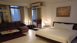 A hotel room with a bed, a sofa, a coffee table, a desk, and a chair. - Berjaya Times Square Apartment (Kuala Lumpur)