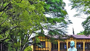 A yellow building with arched windows and a statue in front. - Moderno com Ar condicionado e Academia (São Paulo)