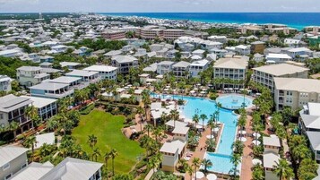 A resort with multiple buildings, a central pool, and surrounding greenery.