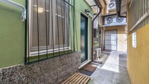 A narrow alleyway with a bench, a green building with a window, and a door. - Hostdomus - Lizzie's House (Alassio)