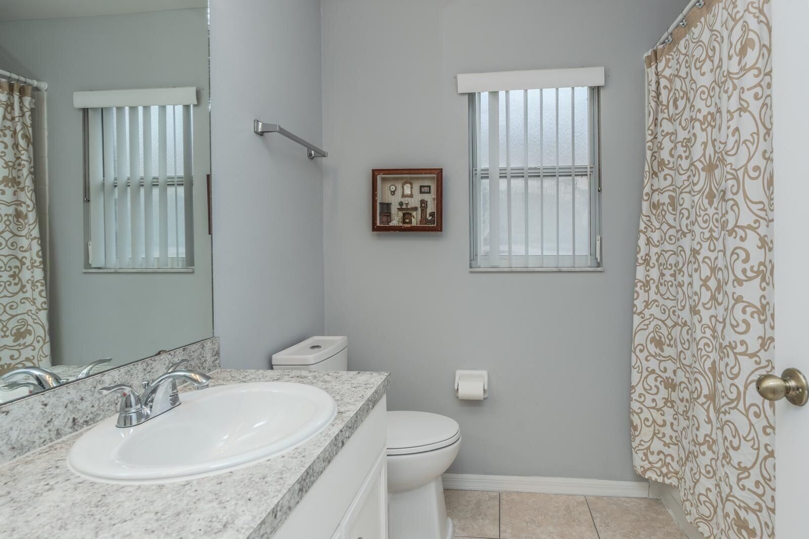 Une salle de bain équipée d’un lavabo, de toilettes et d’un rideau de douche.