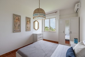 Un dormitorio con cama, cómoda, espejo y armario.