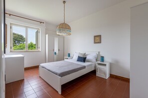 A bedroom with a bed, bedside tables, a hanging light fixture, a window, and a door. - The Hidden Olive Gem by Wonderful Italy (Terrasini)