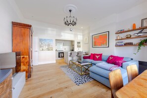 Ein modernes Wohnzimmer mit einer Couch, einem Couchtisch und einer TV-Konsole.