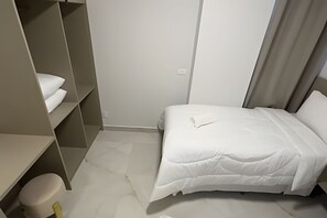A bedroom with a bed, a wardrobe, and a toilet. - Apartamento no centro de Foz do Iguaçu (Foz do Iguaçu)