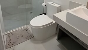 A modern bathroom with a glass shower enclosure, a toilet, and a sink. - Apartamento no centro de Foz do Iguaçu (Foz do Iguaçu)