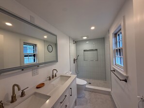 Een douche, een bidet, handdoeken, toiletpapier