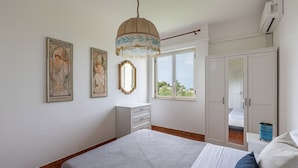 Un dormitorio con cama, cómoda, armario y dos cuadros en la pared.