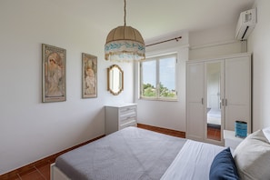 Un dormitorio con cama, cómoda, armario y dos cuadros en la pared.