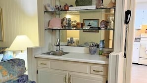 Una cocina pequeña con un lavamanos, armarios y una encimera.
