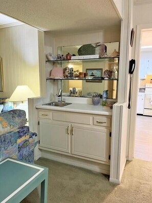 A compact kitchen with a sink, cabinets, and a countertop. - 3 Pools ! Condo at Ocean Isle Beach by Williamson Realty (Ocean Isle Beach)