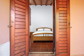 Ein Schlafzimmer mit einem hölzernen Bett, einem Nachttisch und einer Holztür.