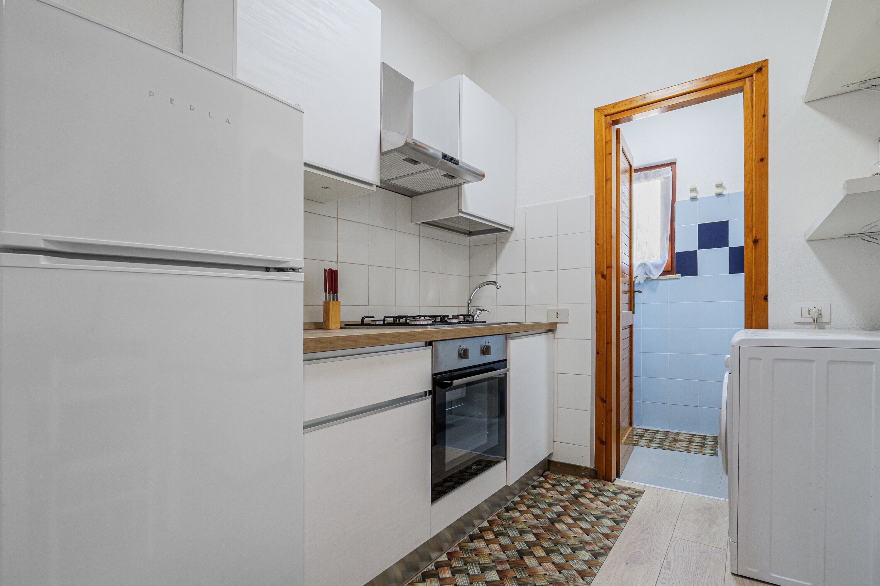 A kitchen with white cabinets, a stove, an oven, and a tiled backsplash.