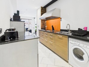 Eine moderne Küche mit Waschmaschine, Toaster und Spüle.