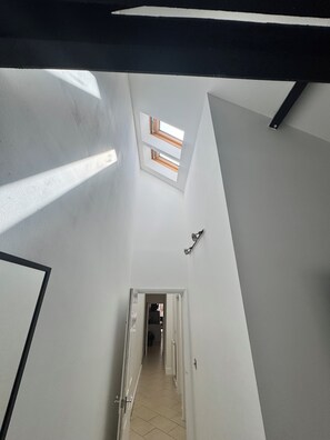 Ein schmaler Flur mit Oberlicht und einer Tür zu einem anderen Raum.