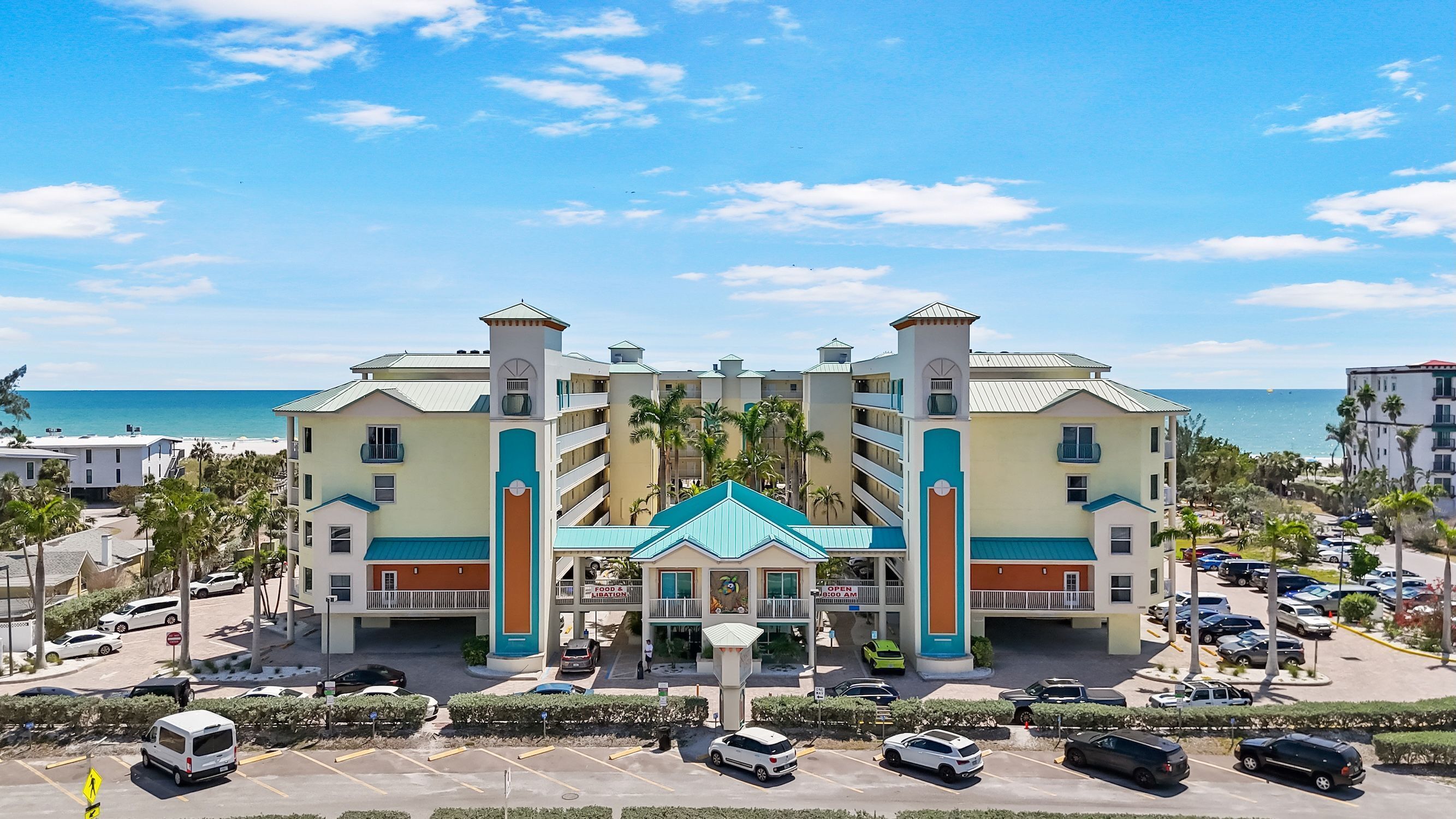 A hotel with a central atrium, multiple floors, and a view of the beach.