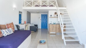 Un appartement moderne avec une chambre en mezzanine, un coin repas et une cuisine.