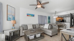 Ein modernes Wohnzimmer mit Sofa, Couchtisch und Essbereich.