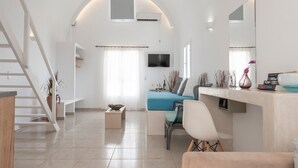 Un soggiorno moderno con una scala, una TV a schermo piatto, un divano e un'area pranzo.