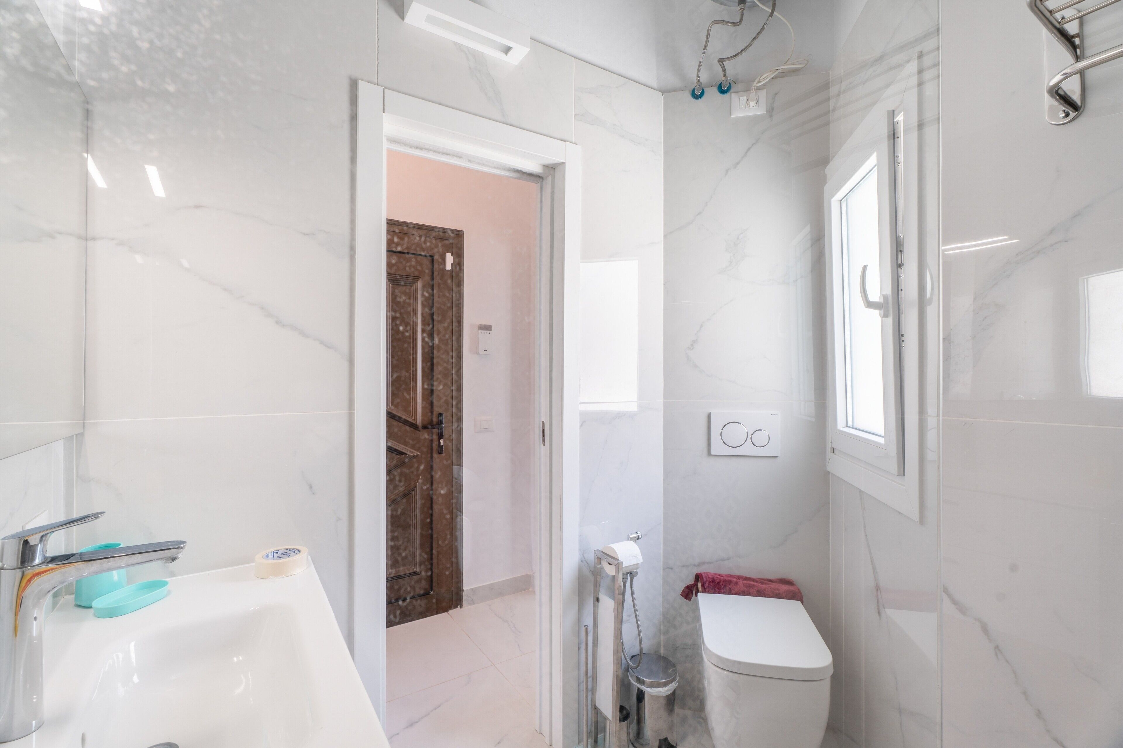 Un baño con lavamanos blanco, inodoro y zona de ducha.