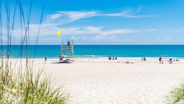 A beach with a lifeguard tower, clear blue sky, and ocean. - Circle View Cottage|Hot Tub·Shed Bar·Walk to Beach (Atlantic Beach)