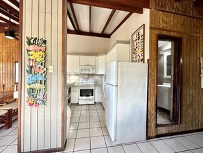 A kitchen with white cabinets, a refrigerator, and a microwave.