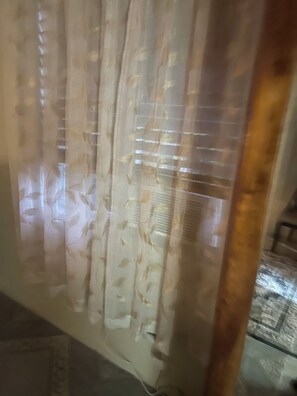Ein Fenster mit transparenten Vorhängen mit einem floralen Muster.