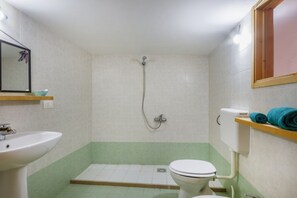Ein Badezimmer mit Waschbecken, Toilette, Dusche und Spiegel.