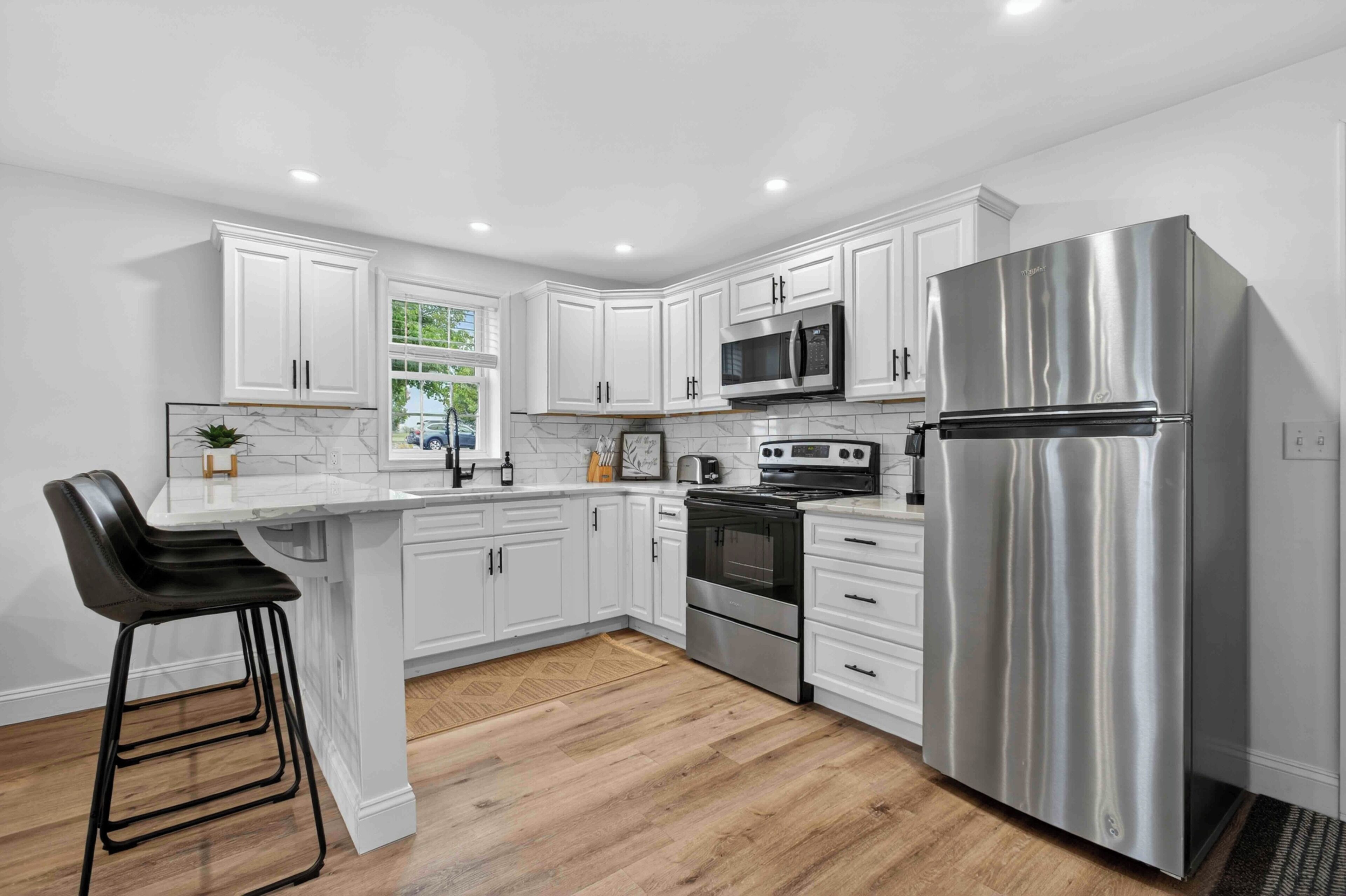 Bright, modern kitchen with stainless appliances and breakfast bar