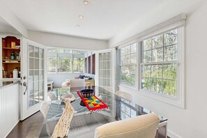A spacious room with a glass table, a colorful rug, and a view of the outdoors. - Dartwood Dunes, Dunes, Lakes, Union Pier, Hot Tub (Union Pier)