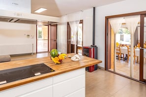 Eine moderne Küche mit Induktionskochfeld, Obstschale und rotem Herd.