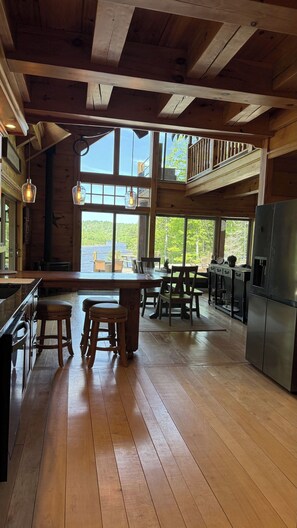 A spacious kitchen with wooden floors, a large island, and a view of a lake.