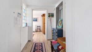A hallway with a patterned rug, a bed with a colorful blanket, and a blue dresser. - Apartment 'La Mansarda - Terrazze Relax A Due' with Balcony, Wi-Fi and Air Conditioning (Cellamare)