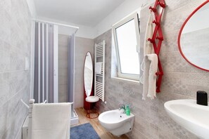 Ein modernes Badezimmer mit Dusche, Toilette, Bidet und Waschbecken.