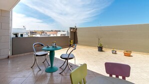 A rooftop terrace with a table and chairs, potted plants, and a view of the cityscape. - Apartment 'La Mansarda - Terrazze Relax A Due' with Balcony, Wi-Fi and Air Conditioning (Cellamare)