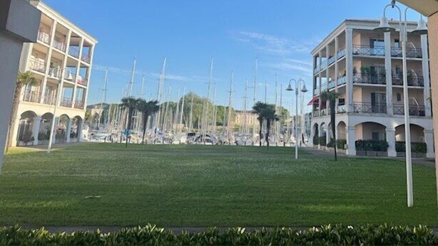 Un hôtel doté d’une pelouse centrale, de nombreux balcons et offrant une vue sur un ciel dégagé.