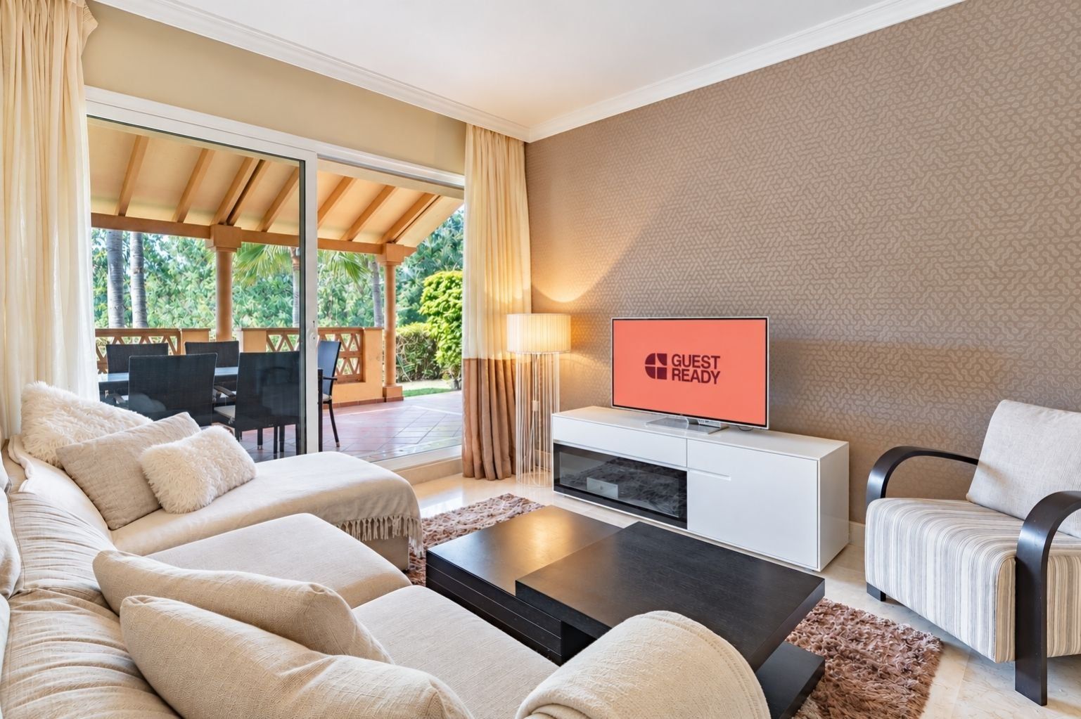 A modern living room with a sofa, a coffee table, a TV, and a dining area with chairs and a table.